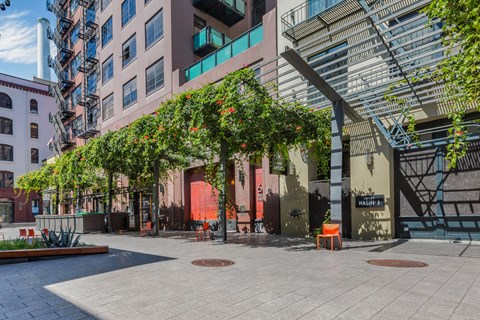 a courtyard with trees and a building with a red door