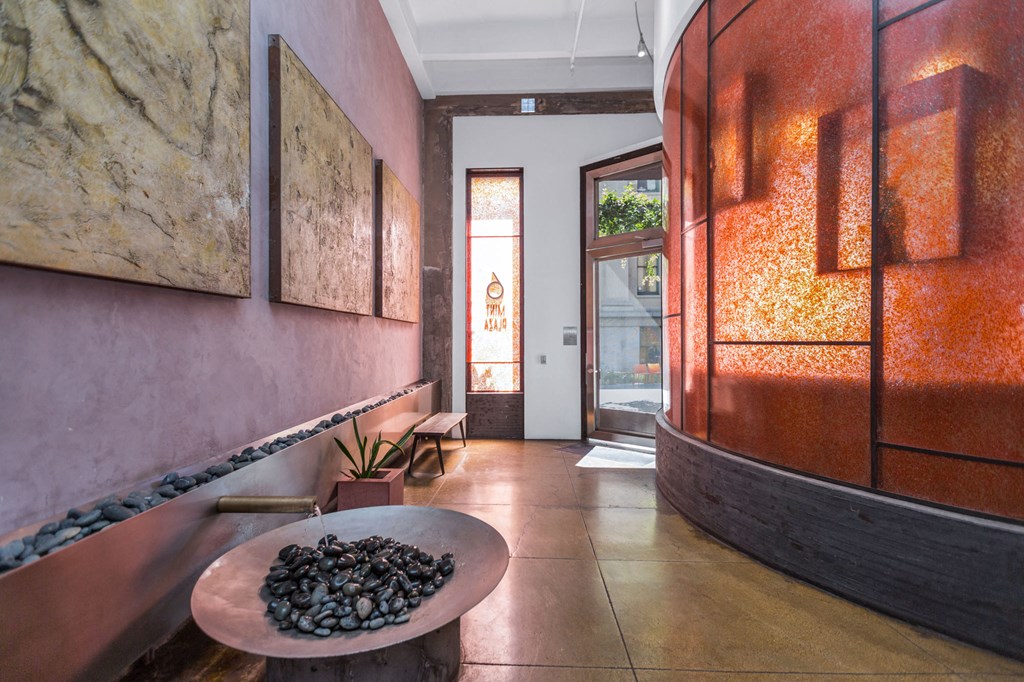 a hallway with pink walls and a table with rocks