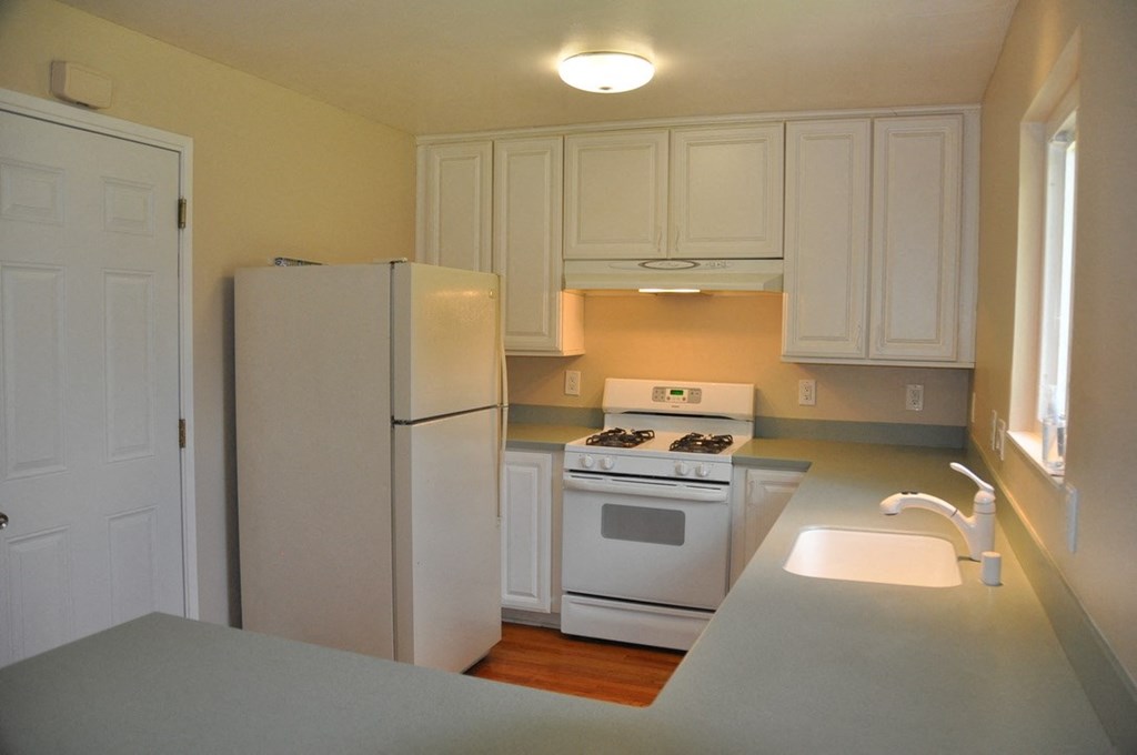 a kitchen with white appliances and white cabinets