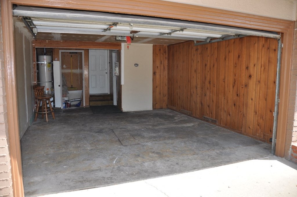 an empty garage with a wooden wall and concrete floor