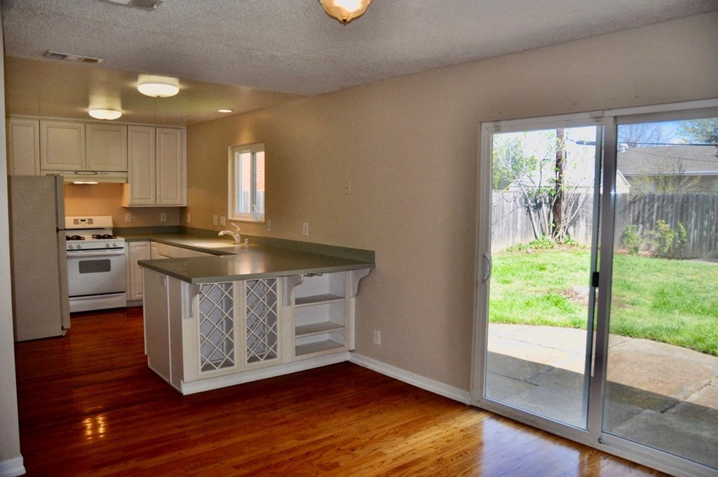 an empty kitchen with an open door to a patio