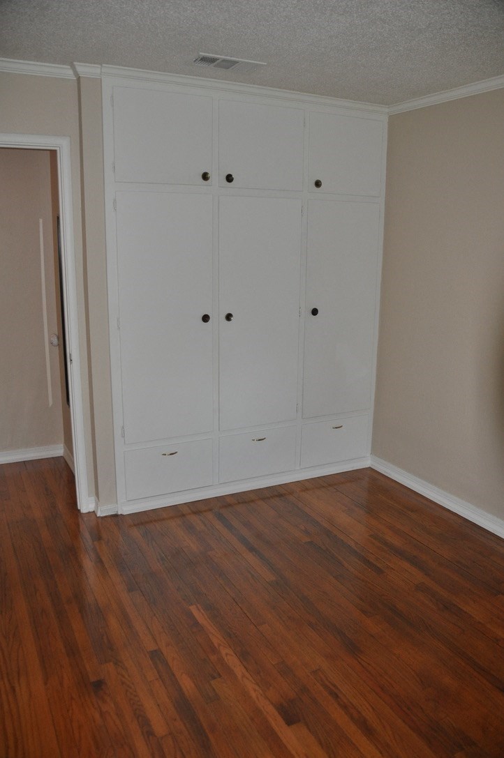 an empty room with wooden floors and white closets