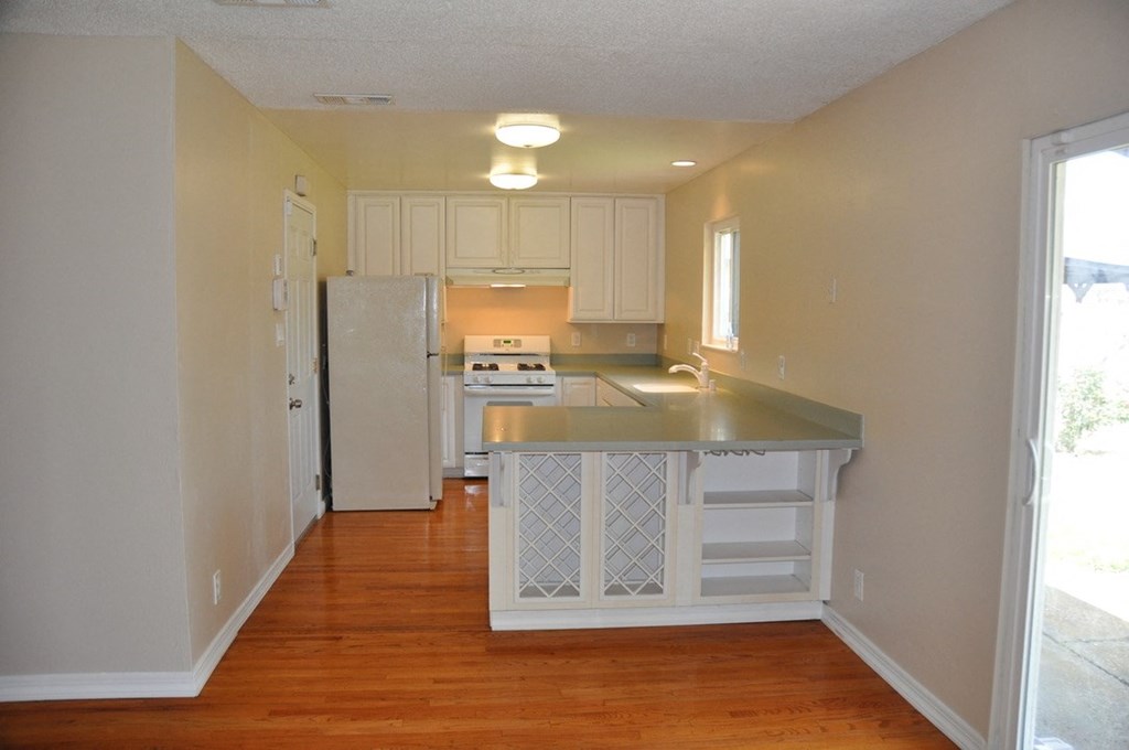 an empty kitchen with an island and a refrigerator