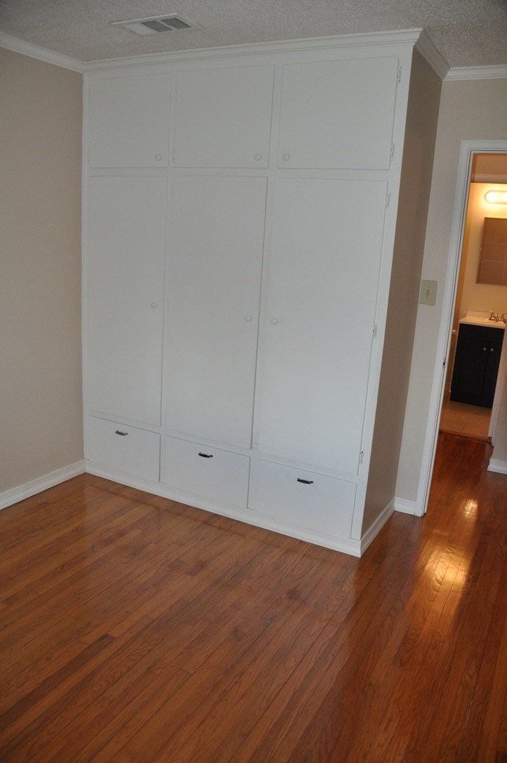 an empty living room with white walls and wooden floors