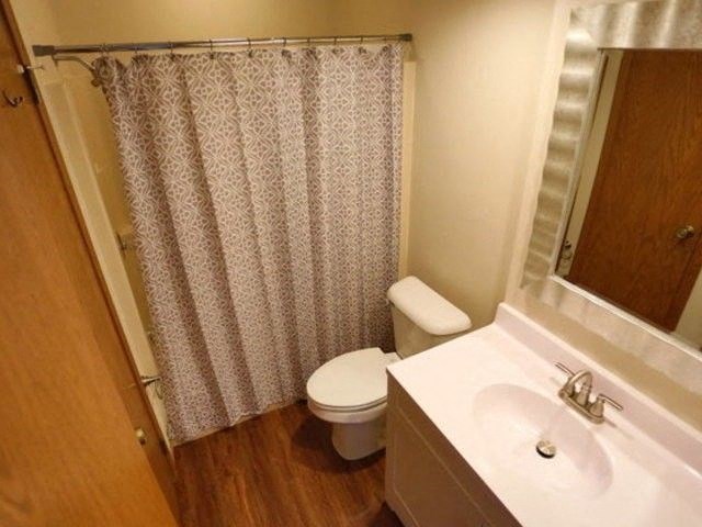 a bathroom with a toilet and a sink and a shower