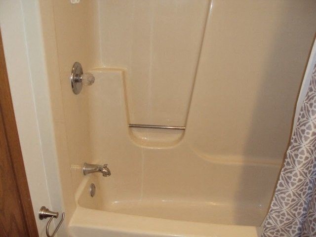 a white shower with a handle in a bathroom