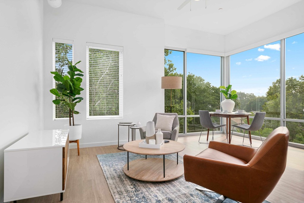 a living room with a large window and a table with chairs