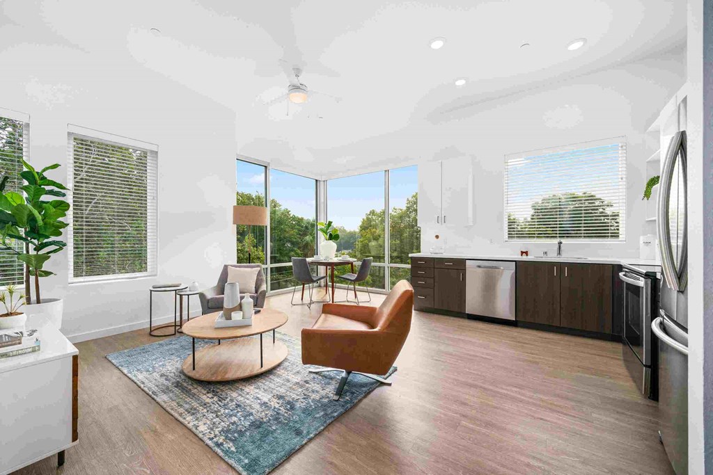 an open living room with a kitchen and a large window