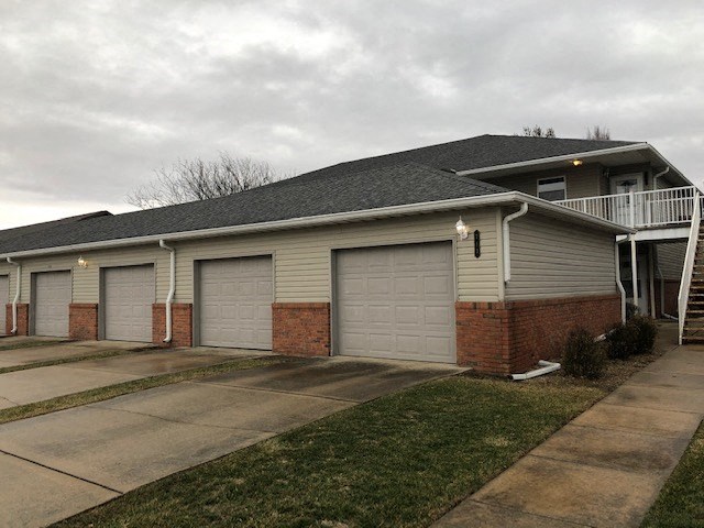 a house with three garage doors and a balcony