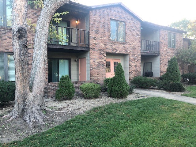 A tree is in front of a brick building.