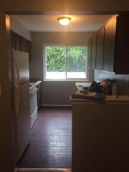 a kitchen with a large window and a white refrigerator