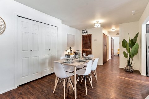 A dining room with a white table and chairs.