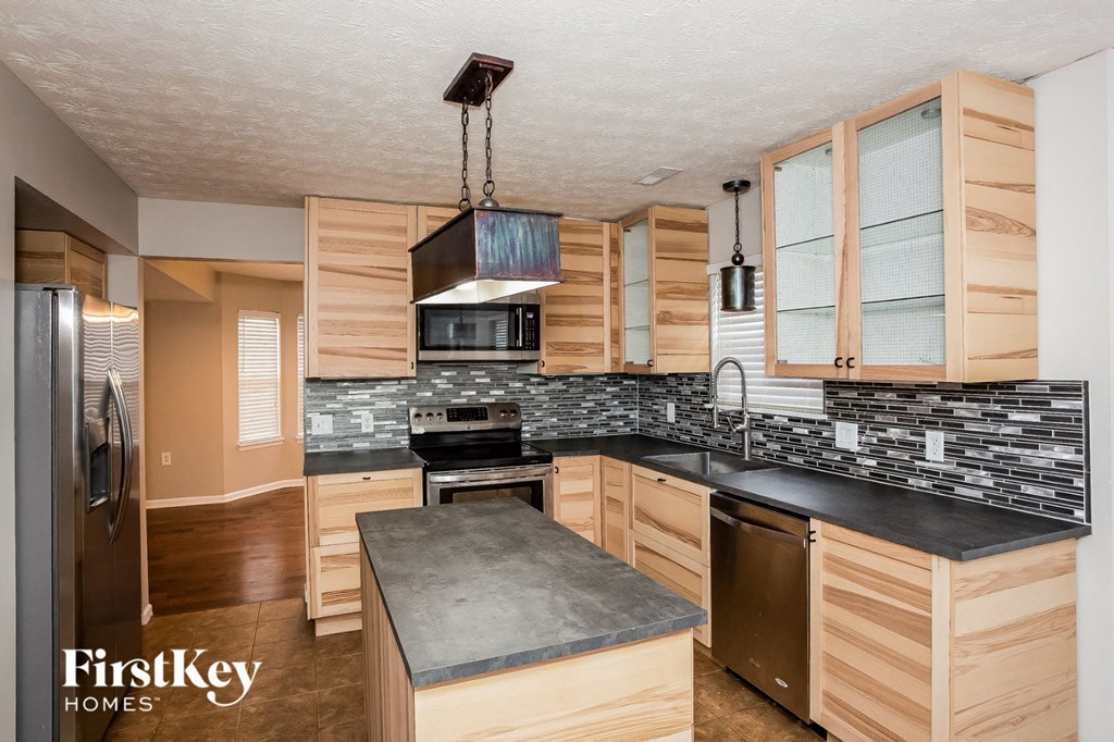 A kitchen with wooden cabinets and a black countertop.
