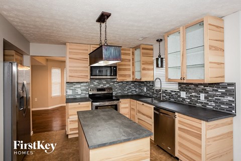 A kitchen with wooden cabinets and a black countertop.