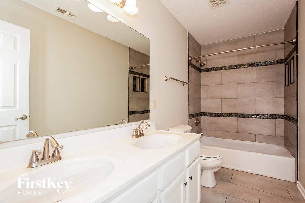 A bathroom with a white sink and a white toilet.