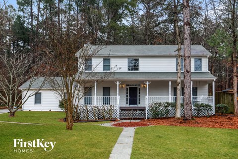 a white house with a front porch and a lawn