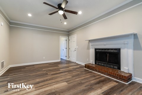 a living room with a fireplace and a ceiling fan