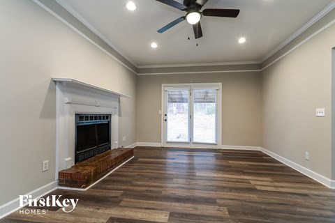 a living room with a fireplace and a ceiling fan