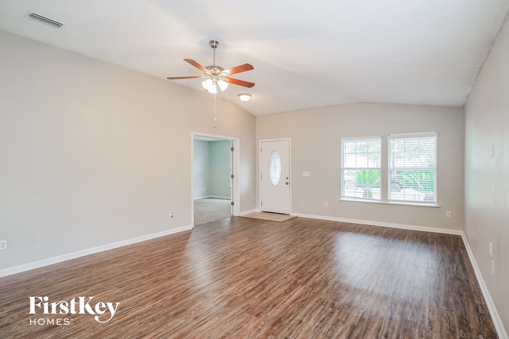A room with wooden floors and a ceiling fan.