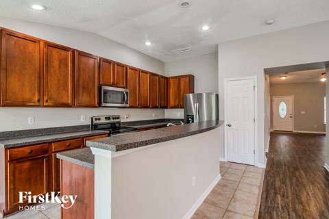 A kitchen with wooden cabinets and a stainless steel refrigerator.