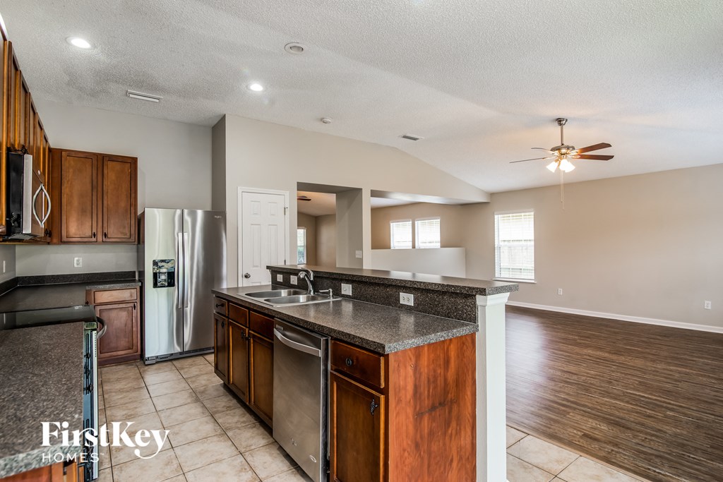 A kitchen with wooden cabinets and a stainless steel refrigerator.