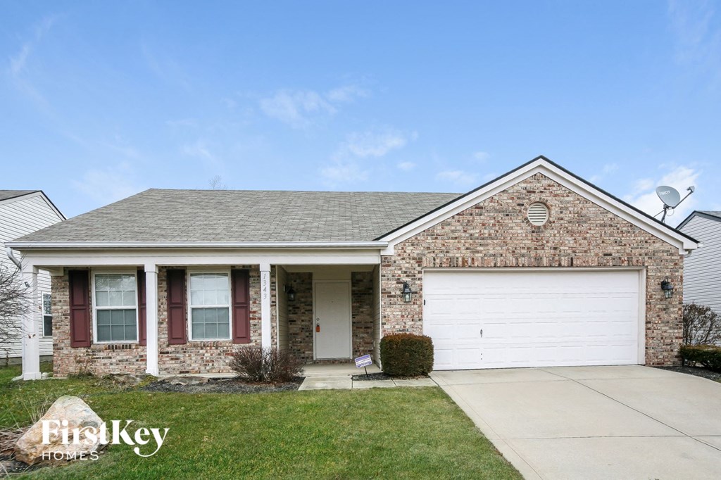 A house with a garage and a driveway in front.