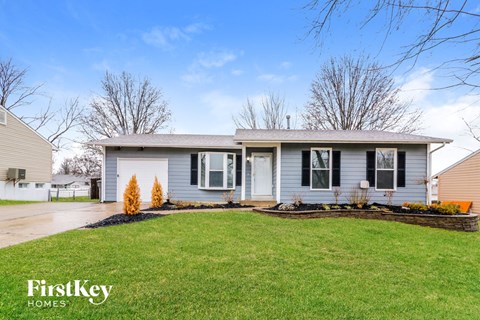 a blue house with a lawn in front of it