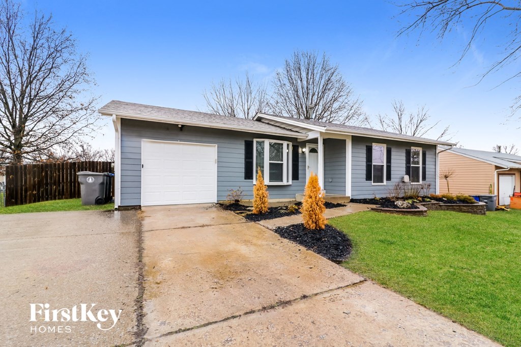 a blue house with a driveway and a white garage door