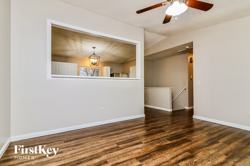 a living room with a large window and a ceiling fan
