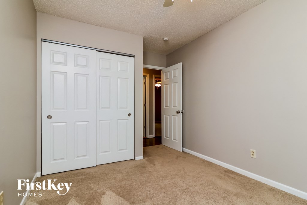 a bedroom with two closets and a door to a hallway