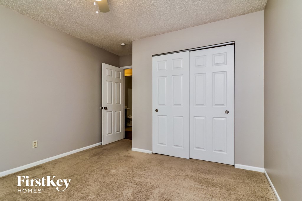a bedroom with two closets and a door to the bathroom