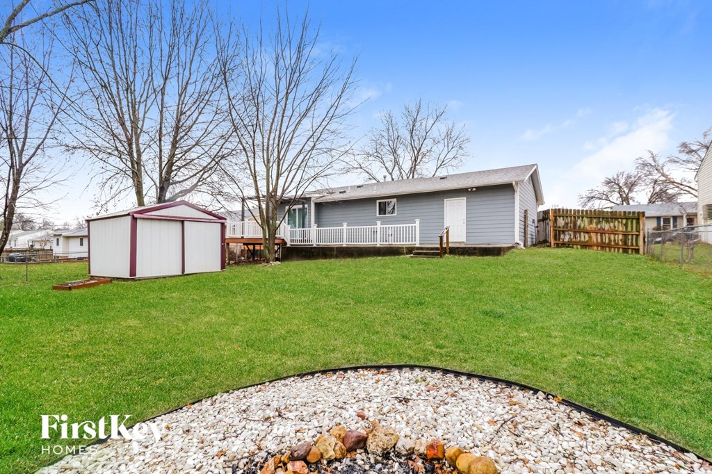 a blue house with a yard and a gravel driveway