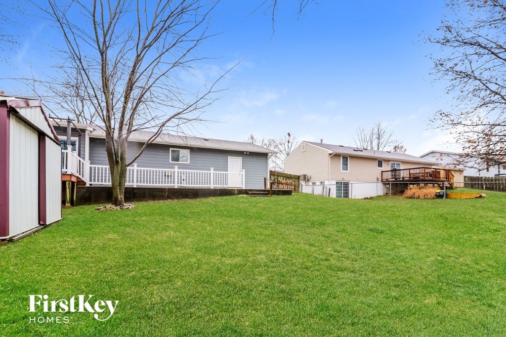 the backyard of a house with a yard and a fence