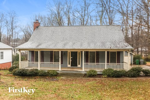 a white house with a porch and a gray roof