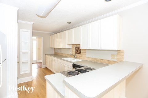a kitchen with white cabinets and a stove and a sink