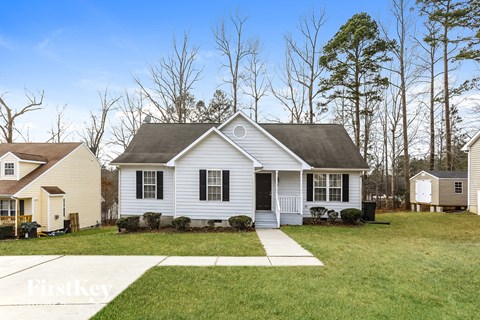 a white house with a lawn and trees