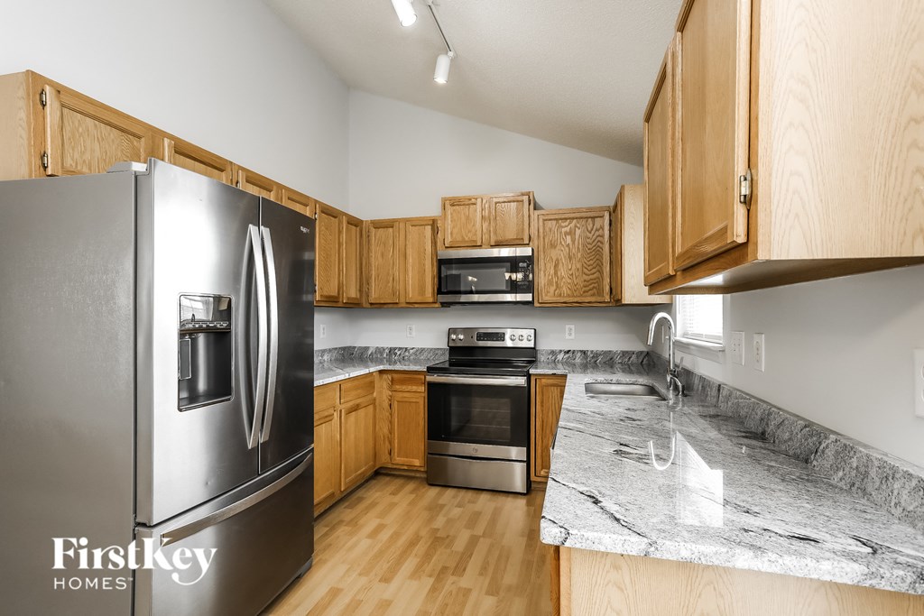 a kitchen with wooden cabinets and stainless steel appliances and granite counter tops