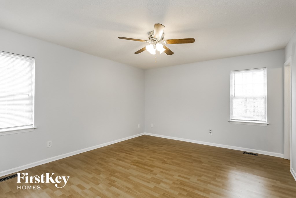 a living room with wood flooring and a ceiling fan