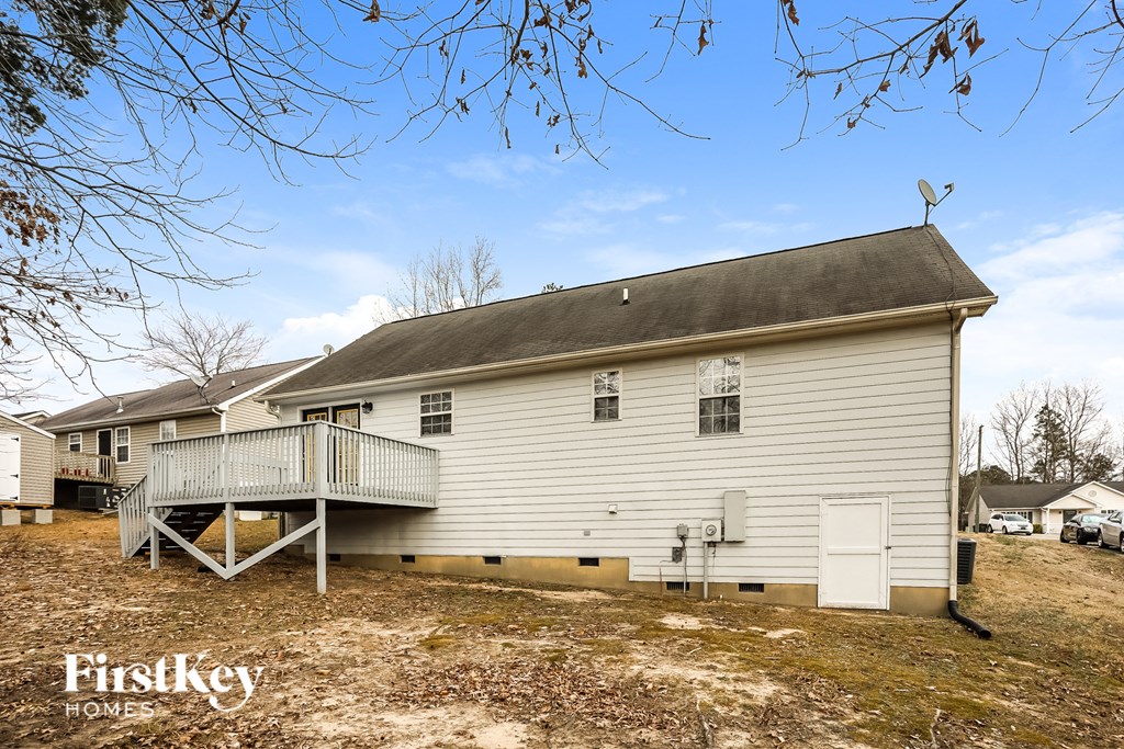 the front of a white house with a porch and a deck