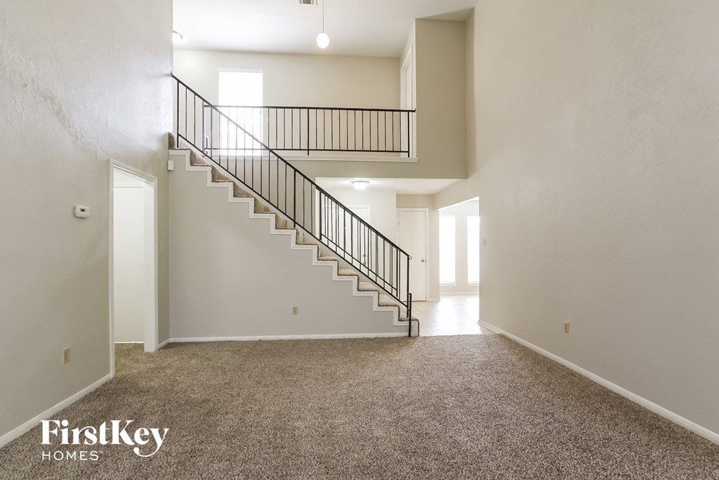 A spacious room with a staircase leading to the upper level.
