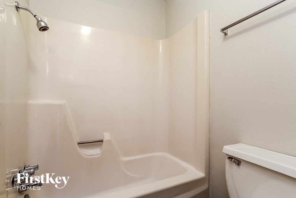 A white bathroom with a tub and toilet.
