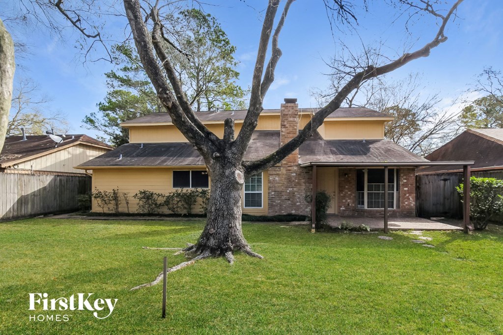 A tree stands in the front yard of a house with a FirstKey Homes logo.