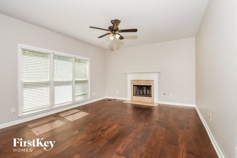 A room with a fireplace and wood flooring.