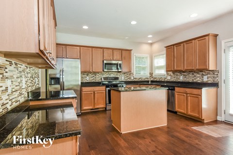 A kitchen with wooden cabinets and a stone backsplash.