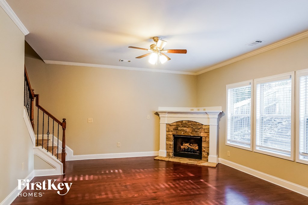 A living room with a fireplace and a staircase.