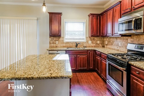A kitchen with wooden cabinets and granite countertops.
