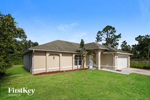 a beige house with a lawn and a garage
