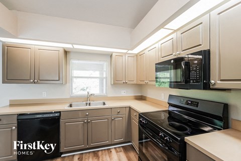 a kitchen with white cabinets and black appliances