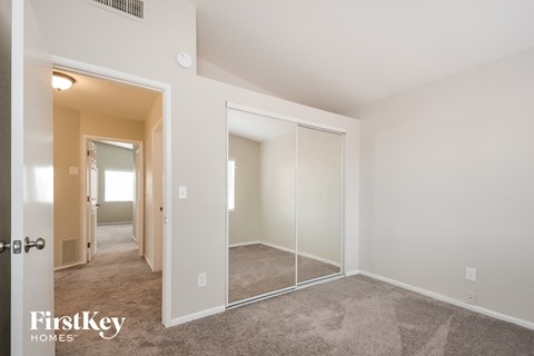 a bedroom with a large mirror and carpeted flooring