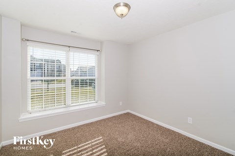 a bedroom with a large window and a carpet
